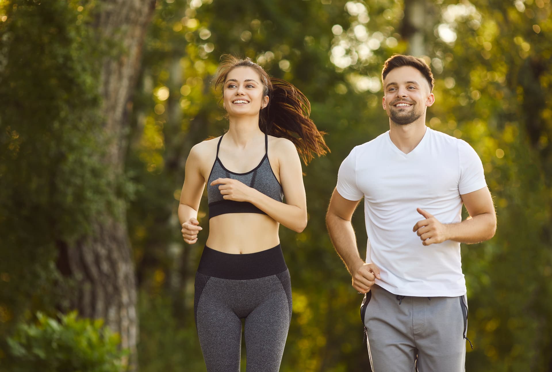 A couple jogging together on a tree-lined path